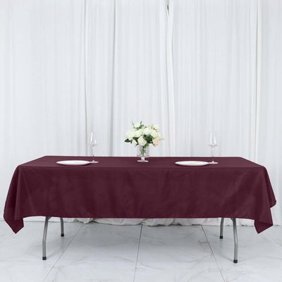 Elegant burgundy tablecloth draped over a dining table with floral centerpiece.