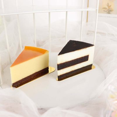 Layered mousse cake slices on a white plate with a soft backdrop.