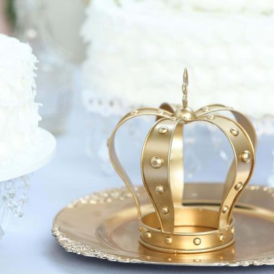 Gold crown centerpiece on a silver plate at a cake display.