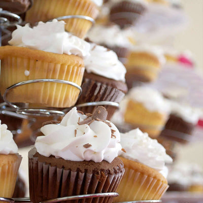 Assorted cupcakes with frosting displayed on a tiered stand.
