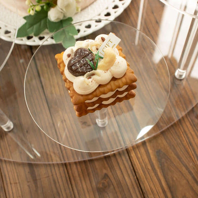 Decorative dessert with cream and chocolate accents on a clear display stand.