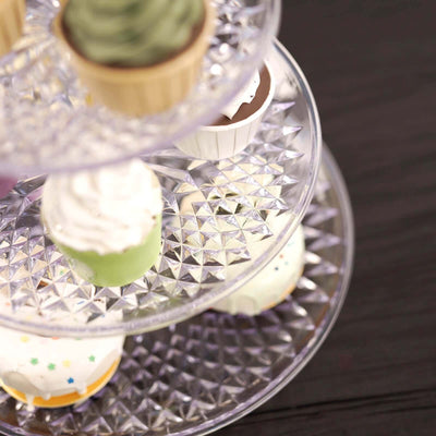 Tiered dessert stand with colorful cupcakes and frosting decorations.