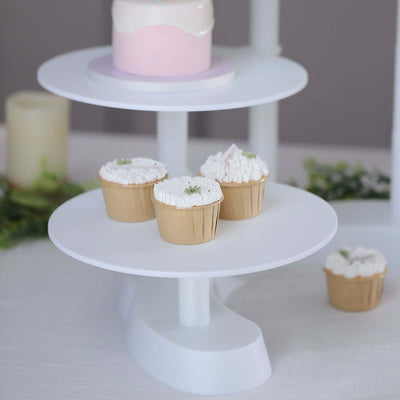 White cupcake stand with decorated cupcakes on two tiers.