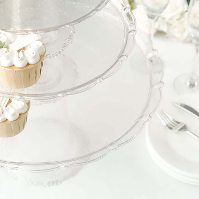 Clear three-tiered cake stand with cupcakes on top.