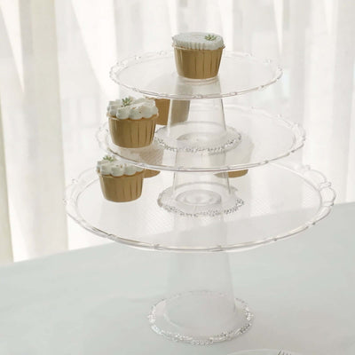 Clear three-tier cupcake stand with decorative edge and cupcakes on top.