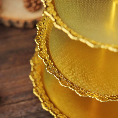 Gold decorative cake boards with intricate lace edges.