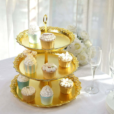 Three-tiered gold cupcake stand with assorted decorated cupcakes.