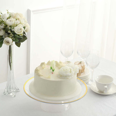 Elegant floral cake on a stand with a bouquet and tableware in a bright setting.