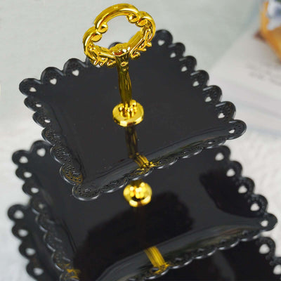 Two-tier black serving platter with a golden handle.