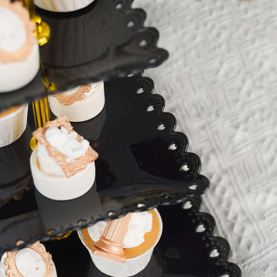 Elegant black tiered cake stand with decorative desserts.