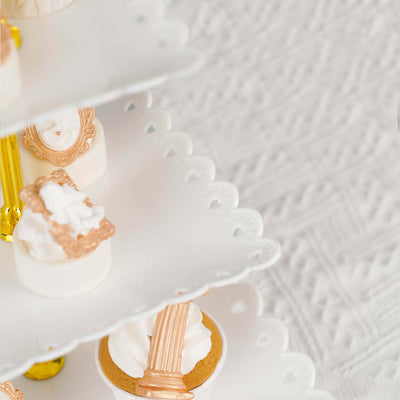 Elegant dessert stand with decorative mini cakes and whipped cream.