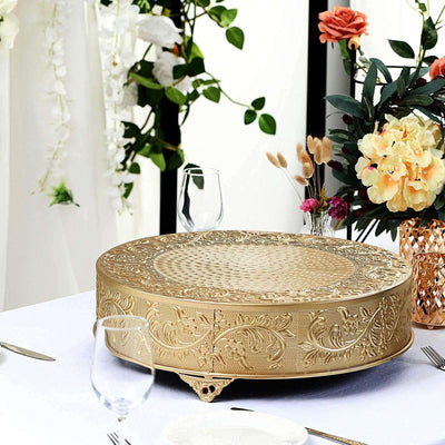 Elegant gold cake stand with intricate floral design on a table setting.