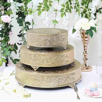 Elegant three-tiered gold cake stand with intricate floral design.