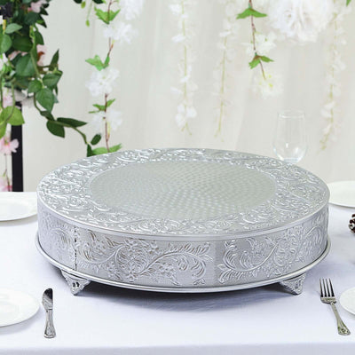 Elegant silver cake stand with intricate floral design on a dining table.