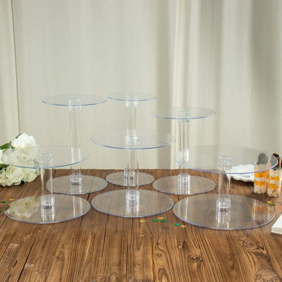 A set of clear acrylic display risers in various heights on a wooden table.