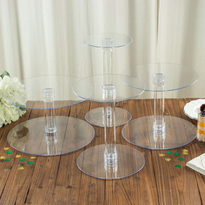 Clear acrylic dessert stands set on a wooden table for events and celebrations.