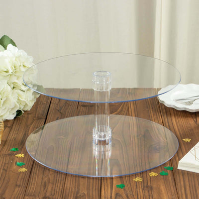 Clear acrylic two-tier cake stand on a wooden table.
