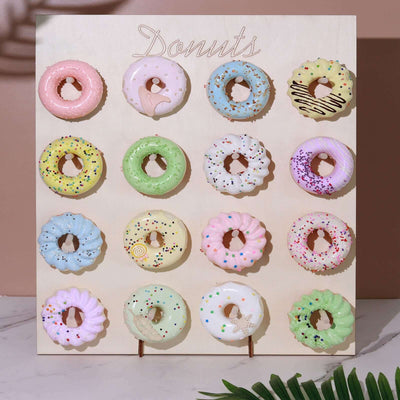 Colorful assortment of decorative donuts on a wooden display board.