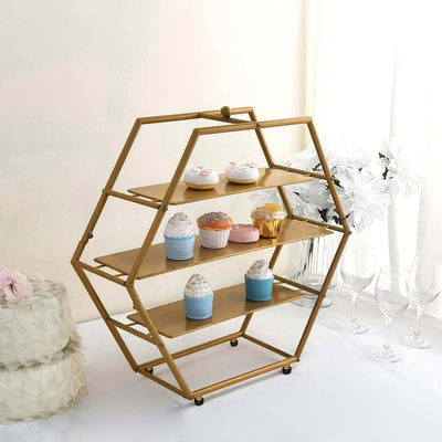 Hexagon-shaped dessert stand displaying colorful cupcakes in a bright setting.