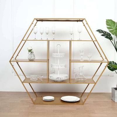 Hexagonal gold shelving unit displaying glassware and plates in a staged setting.