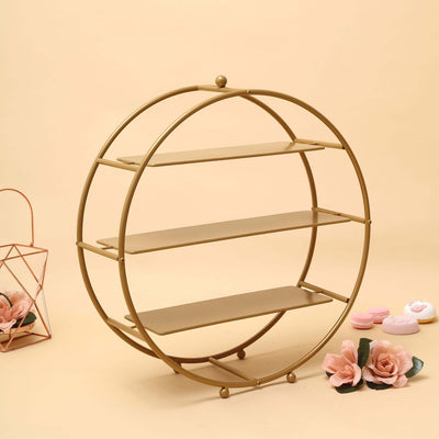 Gold circular shelf with three tiers and decorative flowers.