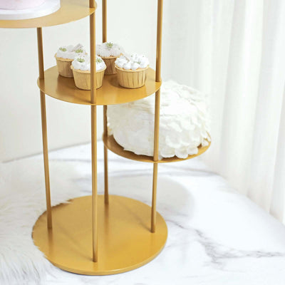 Gold dessert stand with cupcakes and a cake on a marble surface.