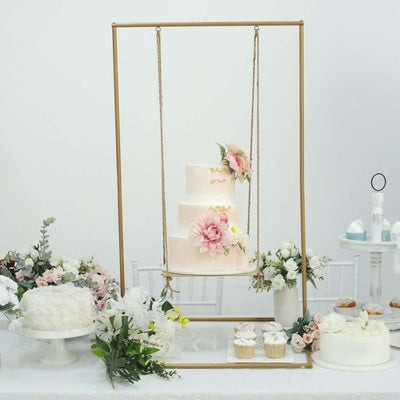 Elegant three-tier wedding cake adorned with flowers on a decorative swing display.
