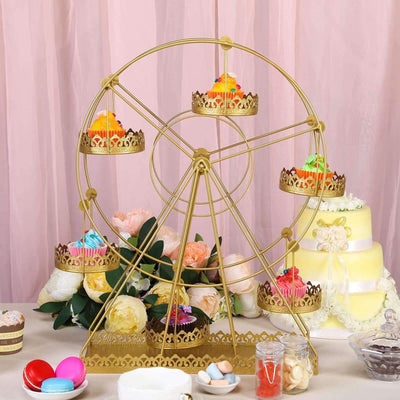 Gold ferris wheel cupcake stand with colorful cupcakes and floral backdrop.