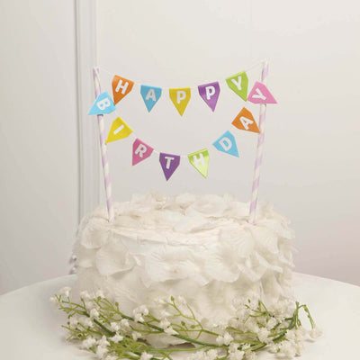 Birthday cake with colorful "Happy Birthday" banner decoration.