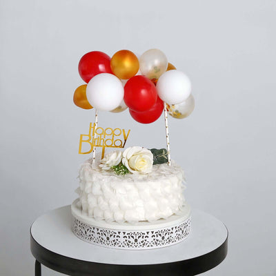 Birthday cake with balloons and decorations on a white table