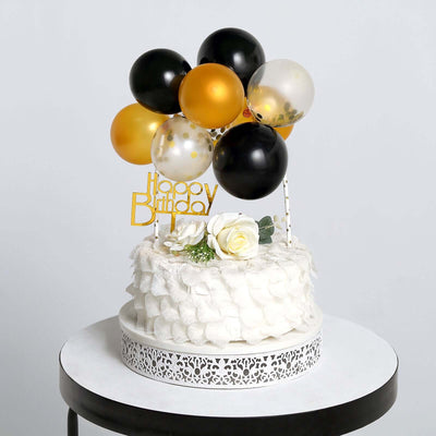 Birthday cake with decorative balloons and a "Happy Birthday" sign on a table.