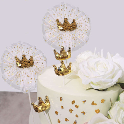 Gold crown cake toppers with white ruffles and glitter for celebrations.