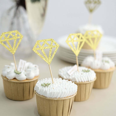 Decorative cupcakes with diamond-shaped toppers on a rustic table setting.