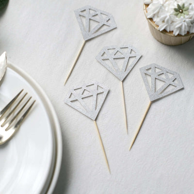 Silver diamond-shaped cupcake toppers on a table setting.