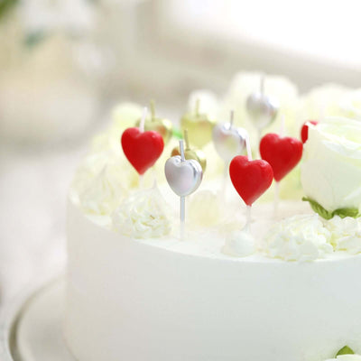 White cake with heart-shaped decorations on top.