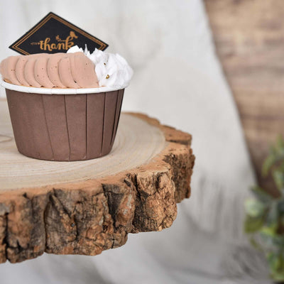 Chocolate mousse dessert in a brown cup topped with whipped cream and a decorative tag.