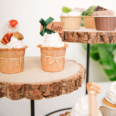 Cupcakes with decorative toppers on rustic wood stands.
