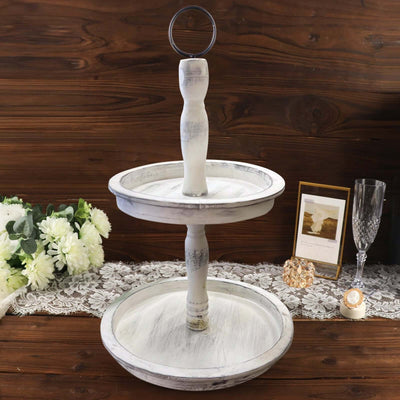 Two-tiered white wooden serving tray with a handle on a rustic wooden background.