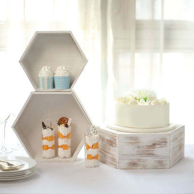 Elegant cake and dessert display on rustic wooden stands in soft natural light.