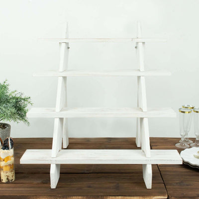 White wooden tiered display shelf on a wooden table.