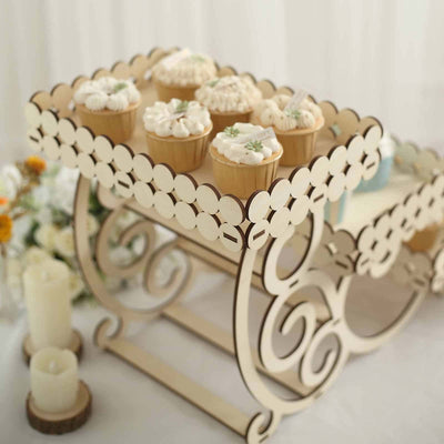 Wooden cupcake stand with decorative edges and cupcakes on top.