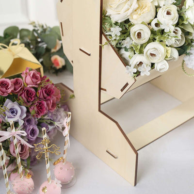 Wooden flower holder with assorted flowers and decorative treats in a styled scene.