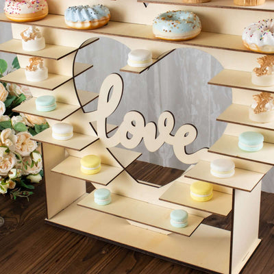 Wedding cake stand with donuts and macarons, heart-shaped design.