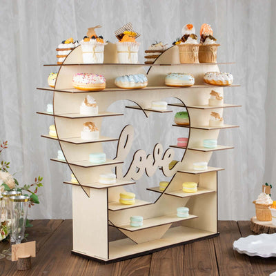 Heart-shaped dessert display stand with cupcakes and macarons.