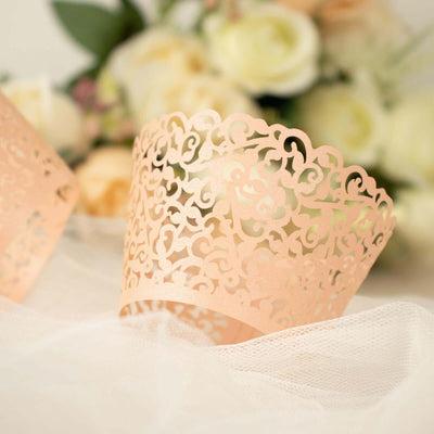 Rose gold lace cupcake wrapper on soft white fabric.