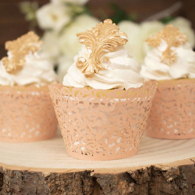 Decorative cupcakes with whipped cream and ornate gold accents on a wooden slice.