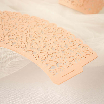 Intricate peach lace paper design on soft fabric backdrop.