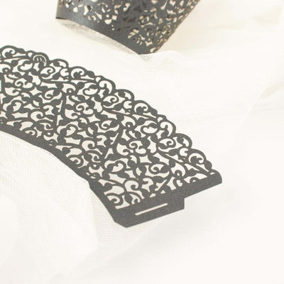 Decorative black lace paper cutouts on a soft white background