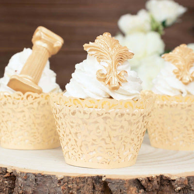 Decorative cupcakes with golden toppers in intricate lace wrappers.