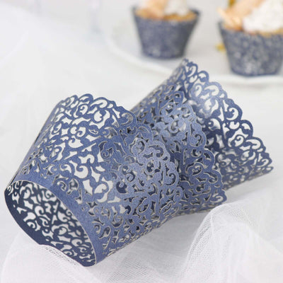 Navy blue lace cupcake wrappers on a white surface